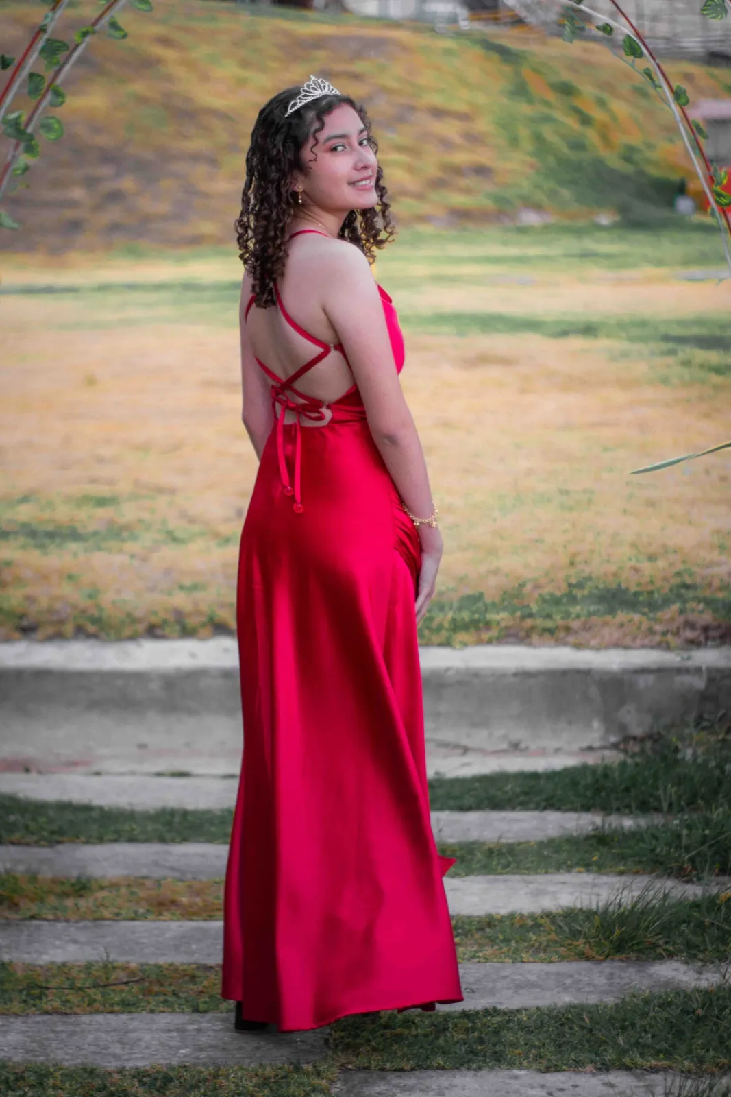 Quinceañera con vestido rojo de satín, vista de espalda