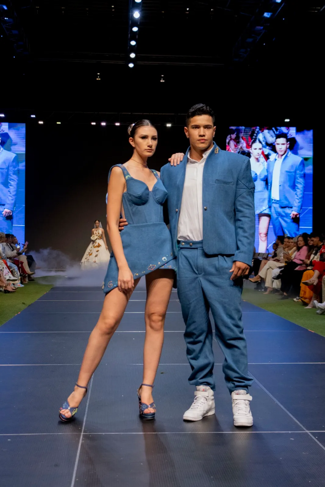 Dos modelos con conjuntos de denim azul en pasarela